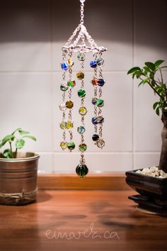 a wind chime hanging from the ceiling next to a potted plant on a table