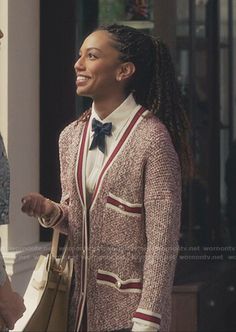 the young woman is talking to her friend on the porch outside their house, wearing a sweater and bow tie