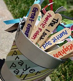 a bucket filled with lots of different colored wooden signs on top of a cement ground