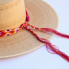 These Beautiful hat bands are carefully hand woven by Rosa in Chiapas,Mexico. Each band showcases a unique and colorful patterned design using traditional macrame techniques. Add a touch of handmade artistry to your hat collection today! Width 1” Length: 23 inches, not including fringe Fringe 9” each side , for an adjustable fit. Fits most hats Polyester yarn All items are shipped from US. All Mi Mundo Mexicano items are 100% handmade by artisans in Mexico. Each stitch and item is completely uni Red Bohemian Brimmed Straw Hat, Red Adjustable Straw Hat For Festivals, Red Adjustable Bohemian Straw Hat, Bohemian Braided Hat Bands For Beach, Casual Woven Hat Bands For Festivals, Bohemian Braided Brimmed Hat, Adjustable Curved Brim Handwoven Panama Hat, Adjustable Woven Straw Hat, Handwoven Adjustable Curved Brim Panama Hat