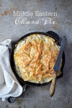 a skillet filled with food on top of a table next to a white towel