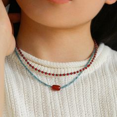 The necklace features stunning blue phosphorus beads that are carefully selected for their vibrant color and iridescent light. Each bead is carefully handcrafted to display intricate patterns and textures that embody the timeless beauty of Chinese art. Metal: Recycled Sterling Silver Plated On Brass Gemstone: Blue Phosphorus,Red Onyx Necklace Chain: 380-430mm Weight: 5-6g Red Seed Bead Necklace, Necklace Beads Ideas, Beads Necklace Ideas, Beaded Necklace Ideas, Red Beads Necklace, Iridescent Light, Bead Chain Necklace, Stacked Necklaces, Red Beads