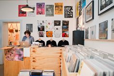 a woman standing in front of a counter filled with records