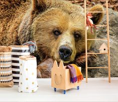 a brown bear laying on top of a pile of stuffed animals next to toys and other items