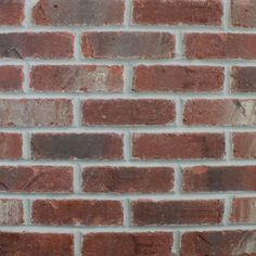 a brick wall that is made out of red and brown bricks, with no mortar or mortar