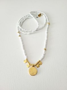 A summer beaded long necklace in white and gold colors. Trendy. Bohemian Chic. Perfect for layering. Description: * white and gold glass beads, also metal beads 24K gold plated brass * Phaistos coin pendant with dot charms, 24K gold plated brass * long necklace, 90cm length when open * toggle clasp closure. White Multi-strand Long Necklace As Gift, Gold Heishi Beads Jewelry For Beach, Handmade Gold Beaded Necklaces For Summer, Gold Necklaces With Tiny Beads For Summer, Summer Gold Necklaces With Tiny Beads, Gold Necklace With Tiny Beads For Summer, Gold Beaded Long Necklace For Festival, Gold Beaded Chain For Summer, Gold Necklaces With Gold Beads For Summer