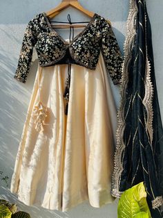 🖤Black And Beige Sabyasachi Lehenga Set. Black sharmily blouse with bold cuts and elegant embroidered in sequin, zardozi and with contrasting beige silk lehenga. and dupatta is in organza with sequin work highlight and scallop edging. This lehenga set can be made in Your Choice COLOR combo. Please message us if you want this in a different color. Blouse: Sequins, zardosi, and embroidery on black Raw Silk fabric. Lehenga: Art raw silk fabric Dupatta: Organza fabric Our products are 100% authenti Transitional Party Anarkali Set With Cutdana, Party Wear Sharara With Unstitched Blouse In Art Silk, Party Wear Art Silk Sharara With Unstitched Blouse, Transitional Party Anarkali Set With Dori Work, Festive Party Wear Raw Silk Blouse Piece, Festive Party Wear Blouse In Raw Silk, Unstitched Art Silk Party Dress, Traditional Drape Gown With Unstitched Blouse For Navratri, Art Silk Dress For Reception