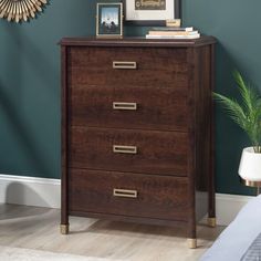 a wooden chest of drawers in a room with blue walls and white carpeted flooring