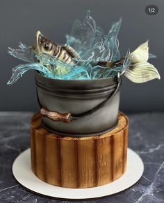 there is a cake that has been decorated with fish in a bowl on top of it