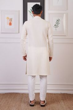 Cream kurta featuring scattered mirror embroidered buttis. Paired with matching pants for a complete look., Fit: Relaxed Fitted Cotton Kurta With Mirror Work, Fitted Cotton Sherwani With Pallu, Fitted Cotton Sherwani For Navratri, Fitted Cotton Traditional Wear With Mirror Work, Fitted Chanderi Kurta With Mirror Work, Fitted Straight Kurta With Mirror Work, Fitted Kurta With Resham Embroidery For Diwali, Diwali Fitted Kurta With Resham Embroidery, Fitted Kurta With Mirror Work For Diwali