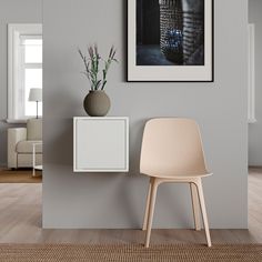 a chair and vase on a shelf in the corner of a room with a painting