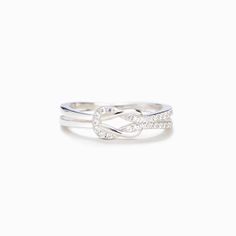 a white gold ring with diamonds in the middle and an intertwined design on top