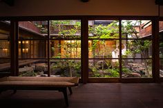 an empty room with lots of windows and plants in the window sill, along with a bench