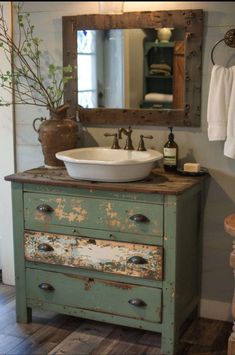 an old dresser has a sink and mirror on it in this rustic bathroom with wood flooring