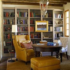 a living room filled with lots of books and furniture