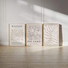 three books sitting on top of a hard wood floor next to each other in front of a white wall