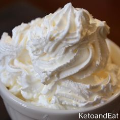 a white bowl filled with whipped cream on top of a table