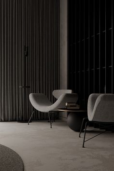 a living room with two chairs and a table in front of a curtained window