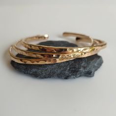 Build your own set! Add two or more items to your cart and enter the code: MOREMETAL during checkout for 15% off of your whole order! These beautiful handmade bronze bangle bracelets are a perfect addition to the MorrisMetalWork lineup! Bangles have been a staple item for this shop since the beginning, and I am proud to offer these hammered bronze bangles to you. The hammered texture on each bangle catches and reflects the light making these bracelets dazzling. This makes them perfect as an 8th anniversary gift for your wife, or a perfect gift for spoiling yourself.  These stacking bangles are formed into an oval shape for comfort, and are meant for a wrist size of about 7 inches. However, you can make them slightly smaller or larger by firmly pressing the ends together, or by pulling them Mali Jewelry, Bronze Cuff Bracelet, Bronze Bangle, Stacking Bangles, Bronze Anniversary, Hammered Bracelet, Hammered Bangles, Bronze Bracelets, 8th Anniversary