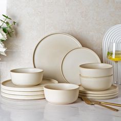 white dishes and cups are arranged on a table