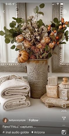 a vase filled with lots of flowers sitting on top of a table next to towels