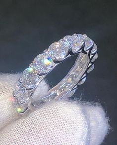 a diamond ring sitting on top of a white glove