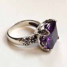 "Hello spring Chunky and fantastic ring, so unique you will never want to take it off. Amazing floral design of such a statement piece with a beautiful Amethyst stone. R2272-2 © 2011 Artisanimpact Inc. All rights reserved. Construction & Dimensions: Sterling silver, clear quartz or lab created amethyst/garnet. Approximate stone size: 14mm (0.55\") x 14mm (0.55\") Please indicate your size in the order. About our jewelry Silvercrush features botanical and organic collection designed and made Elegant Amethyst Open Ring For Wedding, Elegant Open Amethyst Ring For Wedding, Elegant Square Cut Rings With Accent Stones, Wedding Solitaire Ring With Square Cut, Elegant Formal Amethyst Ring With Large Stone, Square Cut Rings With Accent Stones For Wedding, Classic Large Stone Promise Ring, Elegant Promise Ring With Square Cut, Cushion Cut Amethyst Ring With Center Stone For Wedding