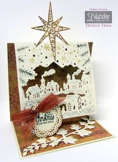 a handmade christmas card with an ornament on it and a star hanging from the top