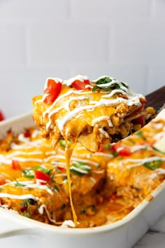 a spoon full of mexican casserole being lifted from the casserole dish