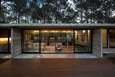 a modern house in the woods with sliding glass doors