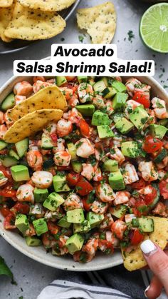 a white bowl filled with shrimp and guacamole salsa next to tortilla chips