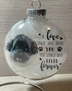 a glass ornament with a black dog's face and words on it