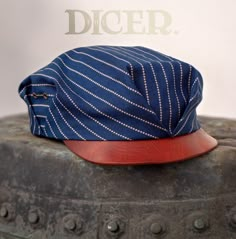 "The DICER Pleated Worker's Cap in Wabash Stripe Workwear Cotton and Vintage Check Cotton Liner Presenting The Dicer - a pleated and lined workwear cap with 'fingernail' horsehide peak. A 'dicer' is a railroad slang term for a fast train, and this cap is aerodynamic and ready to move. The cap's form, including the distinctive inverted V pleating, is inspired by similar designs from the 1900s/10s, though it's my own design strictly speaking. The sides are vented for airflow. This version features Contemporary Wardrobe, Flat Cap, Caps For Sale, Mens Clothing, Men Looks, Well Dressed, Fashion Item, Clothing Items, Caps Hats