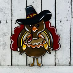 a turkey with a hat on it's head is standing in front of a white fence