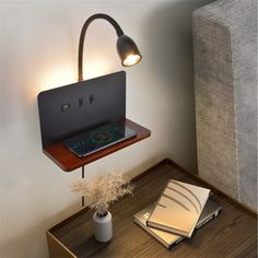 a laptop is sitting on top of a shelf next to a book and lamp in a room