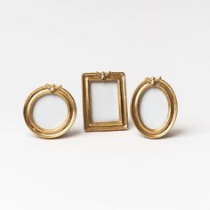 three pairs of gold toned earrings with square frames on each earring side by side