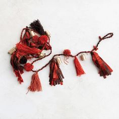 red and brown tassels are hanging on a white wall