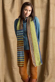 a woman standing in front of a curtain wearing a scarf