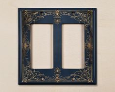 an ornate double switch plate cover in dark blue