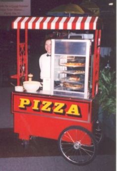 a man standing in front of a pizza cart