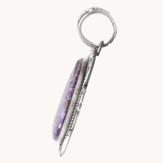 This Charoite Statement Pendant features a one-of-a-kind purple charoite stone, carefully handcrafted with unique silverwork. Made with stunning sterling silver, this pendant is the perfect addition to any jewelry collection. The elegant design adds a touch of sophistication to any outfit, making it a must-have for any fashion-forward individual. Sterling Silver Pendant Charoite Stone 3 1/4" Length (including bail), 1 1/2" Width Artist: R. Tom (hallmarked) Artisan Agate Jewelry With Polished Finish, Purple Amethyst Amulet Jewelry, Unique Purple Round Pendant Jewelry, Spiritual Purple Pendant Jewelry, Silver Agate Engraved Jewelry, Silver Agate Teardrop Pendant Jewelry, Sterling Silver Jewelry With Large Healing Pendant, Artisan Agate Jewelry Engraved, Sterling Silver Teardrop Pendant With Polished Finish