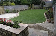 a small backyard garden with grass and flowers