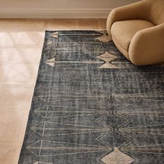 a chair sitting on top of a wooden floor next to a rug