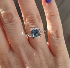 a close up of a person's hand with a blue and white ring on it