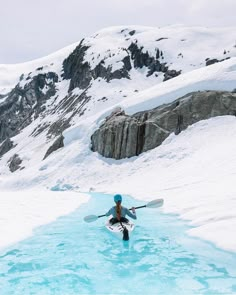 a person is standing in the snow with skis on their feet and holding onto an oar