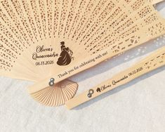 two wooden fans with engraved labels on them