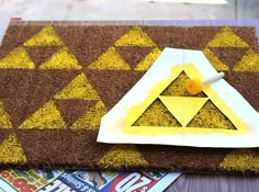 a door mat that has been decorated with yellow and brown designs on it, next to magazines