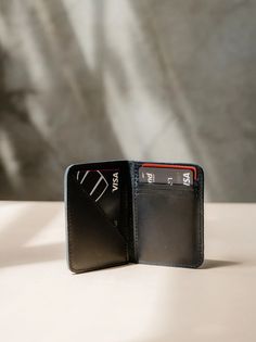 Introducing the ABLE Freddie Card Wallet in sleek black leather. Stay organized and stylish with this functional yet fashionable wallet. Perfect for keeping your cards and cash in one place on-the-go. The Freddie Card Wallet - Character Making, Leather Card Wallet, Funny Socks, Craft Accessories, Leather Texture, Embroidered Pillow, Wallet Fashion, Gift Ideas For Men, Leather Care