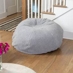 a grey bean bag chair sitting on top of a hard wood floor next to stairs