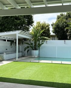 an empty backyard with a pool and grass